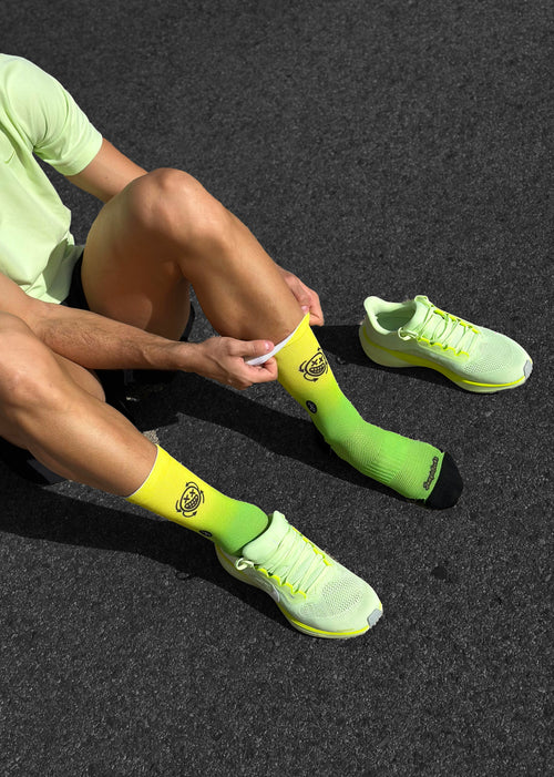 Nahtlose technische Laufsocken, gelb und schwarz, perfektes Kaffeedesign für Asphaltmarathons.