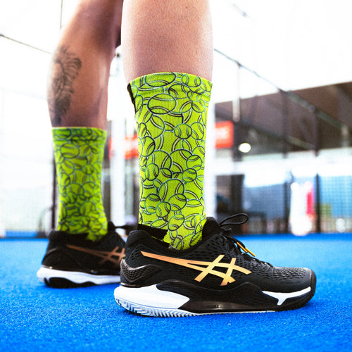 Technische Padel-Socken, Design mit grünen Bällen, nahtlos, ideal für Grip und Bremsen.