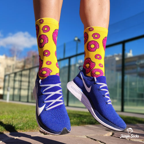 Nahtlose technische Crossfit-Socken mit rosa Donut-Design auf gelbem Hintergrund.