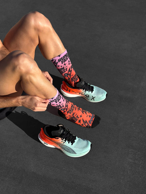 Nahtlose technische Laufsocken, Farbverlauf von Rosa zu Orange mit schwarzem Text und Blitzen.