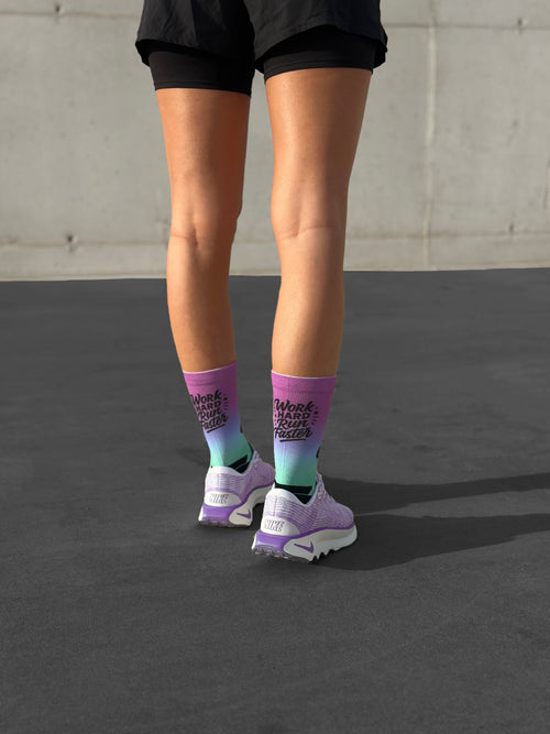 Technische Laufsocken, lila-blauer Farbverlauf, motivierende Botschaft, nahtloses Design ideal für Marathons.