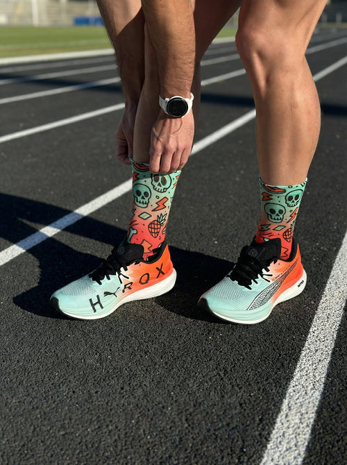 Nahtlose technische Laufstrümpfe, Design mit grünen und roten Neon-Schädeln, perfekt für den Marathon.